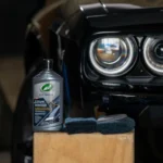 Turtle Wax Black Polish 414ml with infographic callouts showing colour enhancement, light scratch removal, and ceramic acrylic protection on white background