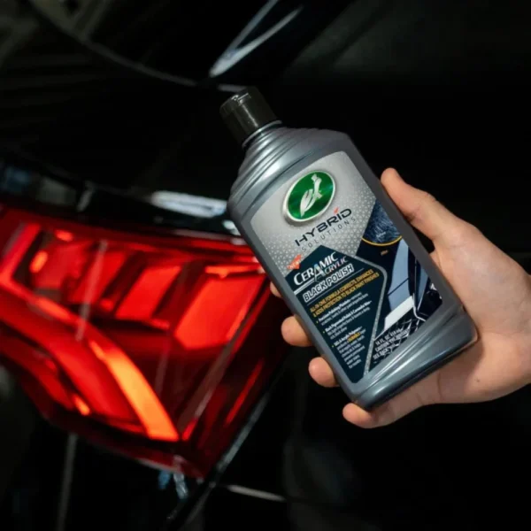 Turtle Wax Hybrid Solutions Black Polish 414ml placed beside a clean black car panel mid-polish on white background