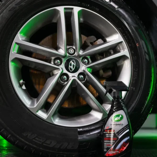 Bottle of Turtle Wax Graphene Tyre Shine 680ml next to wheel with product applied to half the wheel for comparison of effect.