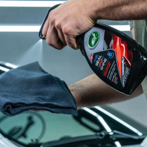 Turtle Wax Ice Seal N Shine 473mL placed next to a clean car panel mid-application on white background